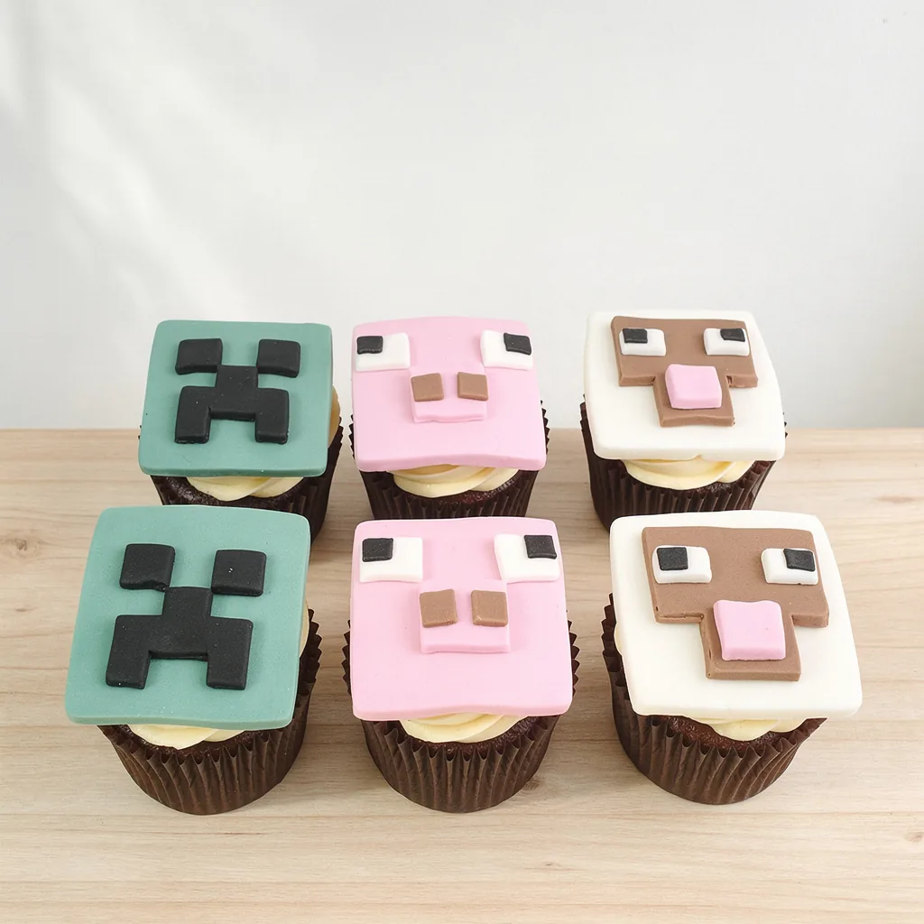 Cupcakes decorated with Minecraft-themed fondant faces including creeper, pig, and sheep